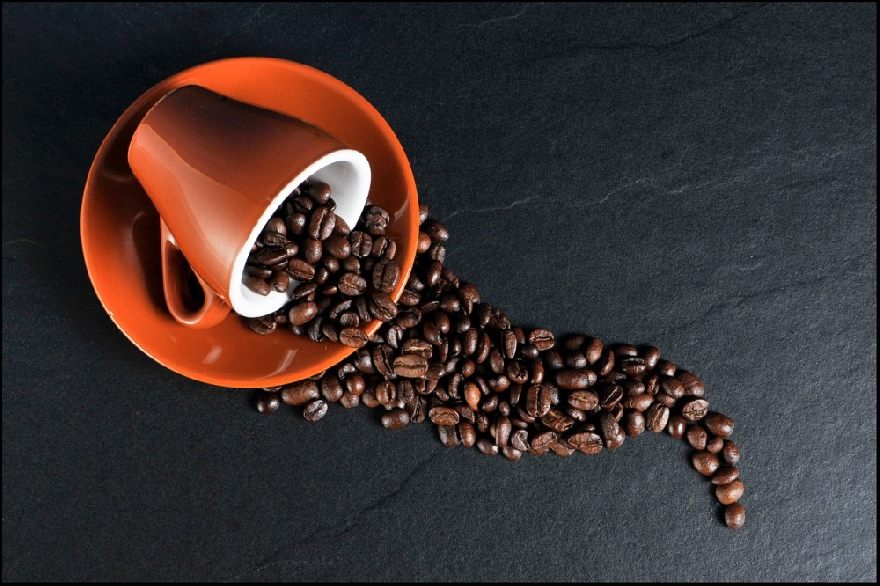 Coffee cup with coffee beans poured out